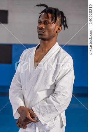 African american man practicing martial arts at dojo in white gi jacket and belt 140928219
