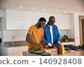 African american father and son slicing bread and cheese in kitchen on cutting board 140928408