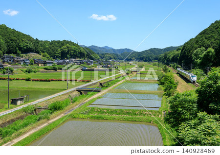 A limited express train on the San'in Main Line speeds from Osaka to Kinosaki, passing by rice paddies where planting has just finished. A limited express train on the San'in Main Line speeds from Osaka to Kinosaki, passing by rice paddies where planting has just finished. 140928469
