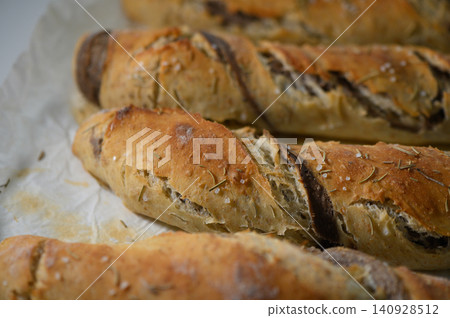 Freshly baked artisan bread loaves with a golden crust and aromatic herbs ready to be enjoyed Freshly baked artisan bread loaves with a golden crust and aromatic herbs ready to be enjoyed 140928512