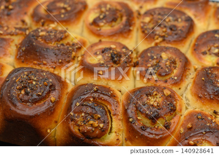 Freshly baked cinnamon rolls with a golden crust and a nutty topping, perfect for a cozy morning moment in the kitchen Freshly baked cinnamon rolls with a golden crust and a nutty topping, perfect for a cozy morning moment in the kitchen 140928641