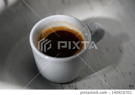 Sipping rich espresso in a cozy cafe during a quiet morning Sipping rich espresso in a cozy cafe during a quiet morning 140928701
