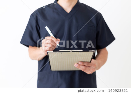 一位身穿藏藍色手術服的中年男醫生,手裡拿著一疊病人問卷。 一位身穿藏藍色手術服的中年男醫生,手裡拿著一疊病人問卷。 140928831