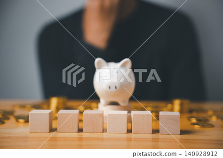 Piggy bank, wooden blocks and coins on a wooden table. Piggy bank, wooden blocks and coins on a wooden table. 140928912