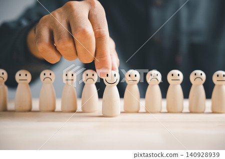 Hand choosing a wooden figure as the chosen leader from the crowd Hand choosing a wooden figure as the chosen leader from the crowd 140928939