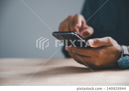 Close-up of hands holding a smartphone with a blurred background and a watch. Close-up of hands holding a smartphone with a blurred background and a watch. 140928944