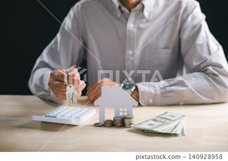 Man holding house keys for real estate property, mortgage loan investment buy home, diligently calculating financial planning with money and calculator to secure property ownership Man holding house keys for real estate property, mortgage loan investment buy home, diligently calculating financial planning with money and calculator to secure property ownership 140928958