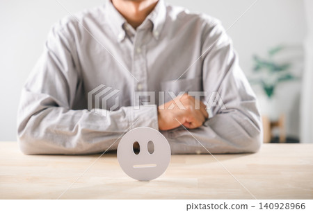 Satisfaction for customer feedback survey indicates neutral service quality, icon rests on smooth wooden table, person considers evaluation results for improved experience Satisfaction for customer feedback survey indicates neutral service quality, icon rests on smooth wooden table, person considers evaluation results for improved experience 140928966
