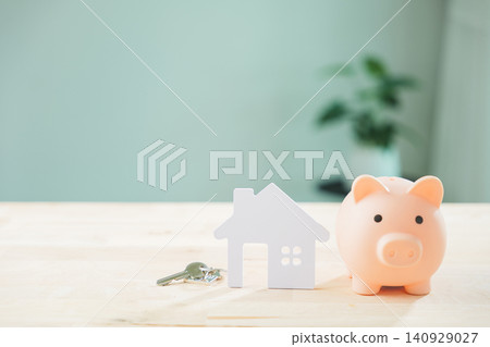 Real estate money investment using piggy bank for home house property saving plus insurance on wooden table beside keys to save for future residential mortgage planning strategy Real estate money investment using piggy bank for home house property saving plus insurance on wooden table beside keys to save for future residential mortgage planning strategy 140929027