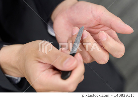 Asian businessman getting his nails done. Asian businessman getting his nails done. 140929115