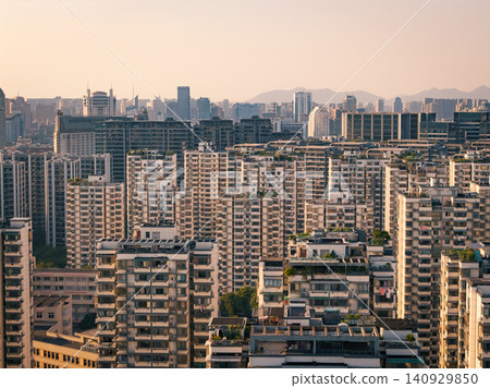 Extensive residential buildings fill a vast urban landscape under warm evening light in a bustling Chinese city Extensive residential buildings fill a vast urban landscape under warm evening light in a bustling Chinese city 140929850