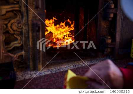 A close-up of the traditional Taiwanese temple ritual of burning joss paper and devout believers. A close-up of the traditional Taiwanese temple ritual of burning joss paper and devout believers. 140930215