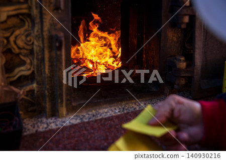 A close-up of the traditional Taiwanese temple ritual of burning joss paper and devout believers. A close-up of the traditional Taiwanese temple ritual of burning joss paper and devout believers. 140930216