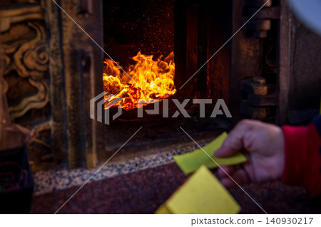 A close-up of the traditional Taiwanese temple ritual of burning joss paper and devout believers. A close-up of the traditional Taiwanese temple ritual of burning joss paper and devout believers. 140930217