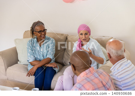Diverse senior support group members sitting on sofa sharing thoughts with coffee mugs Diverse senior support group members sitting on sofa sharing thoughts with coffee mugs 140930686