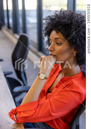 African american woman sitting at office desk gazing toward windows, copy space African american woman sitting at office desk gazing toward windows, copy space 140930918