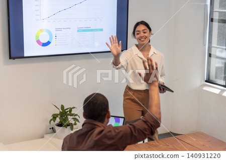 Diverse coworkers analyzing data on display at conference room, tablet, laptop, plant, copy space Diverse coworkers analyzing data on display at conference room, tablet, laptop, plant, copy space 140931220
