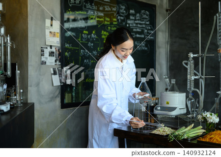 Young Asian Female Scientist in White Lab Coat Working with Botanical Ingredients and Distillation Equipment in Laboratory Young Asian Female Scientist in White Lab Coat Working with Botanical Ingredients and Distillation Equipment in Laboratory 140932124