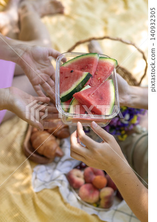 Friends Sharing Slices of Watermelon at Summer Outdoor Picnic Friends Sharing Slices of Watermelon at Summer Outdoor Picnic 140932305