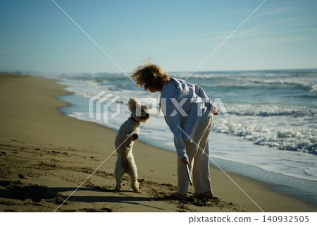 Teen Girl Training Lagotto to Fetch on Sandy Beach Teen Girl Training Lagotto to Fetch on Sandy Beach 140932505