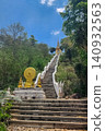 Buddhist temple staircase with naga balustrades and golden Dharmachakra shrine leading to hilltop pagoda in Pattaya, Thailand 140932563