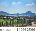 Castello di Bellagio garden grounds with gazebos, pine trees and lake view against tropical hills in Pattaya, Thailand 140932566