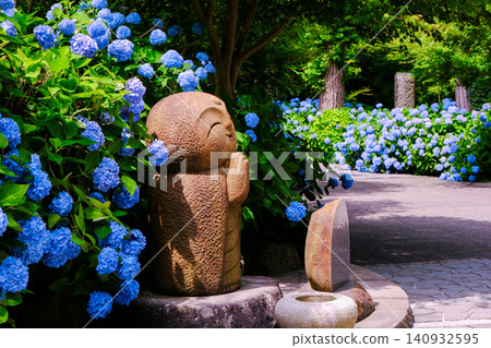 Jizo statue surrounded by hydrangeas 140932595