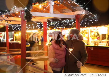 Happy couple spending time at Christmas fair Happy couple spending time at Christmas fair 140932781