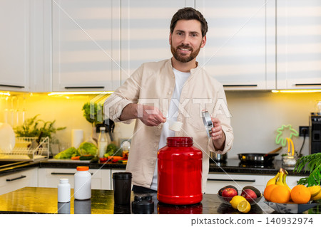 Middle-aged man making protein shake with milk in kitchen for healthy fitness workout diet nutrition Middle-aged man making protein shake with milk in kitchen for healthy fitness workout diet nutrition 140932974