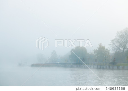 Misty autumn waterfront city district shrouded in atmospheric pollution smoke Misty autumn waterfront city district shrouded in atmospheric pollution smoke 140933166