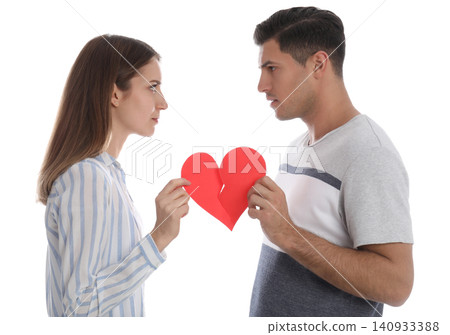 Couple tearing paper heart on white background. Relationship problems Couple tearing paper heart on white background. Relationship problems 140933388