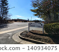 The entrance to the community or Chadds Ford Road, a white sign with bird silhouettes, surrounded by trees and bushes. Nearby is the road and the high school building 140934075