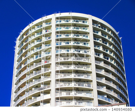 Tower apartments and a cityscape under a blue sky Tower apartments and a cityscape under a blue sky 140934080