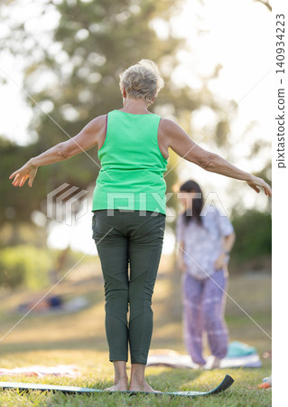 Senior woman practicing yoga outdoors in a park Senior woman practicing yoga outdoors in a park 140934223