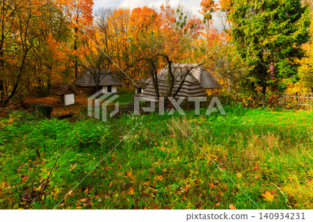 Ukrainian village houses nestled among vibrant autumn foliage in October 140934231