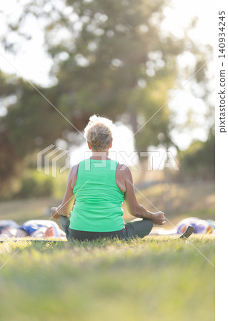 Senior woman meditating in lotus position outdoors Senior woman meditating in lotus position outdoors 140934245