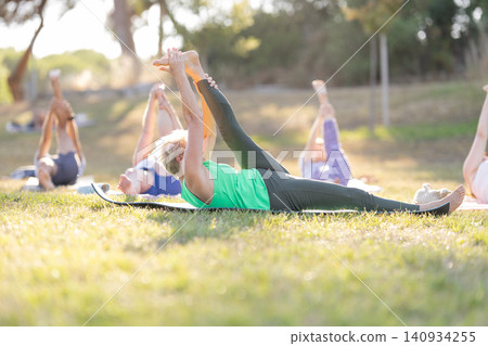 Senior women practicing yoga outdoors in a park Senior women practicing yoga outdoors in a park 140934255