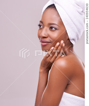 Black woman, space and hair towel in studio with skincare, wellness or beauty on purple background. Makeup, cleaning or hands on face of calm female model touching soft, skin or cosmetic glow results Black woman, space and hair towel in studio with skincare, wellness or beauty on purple background. Makeup, cleaning or hands on face of calm female model touching soft, skin or cosmetic glow results 140934630