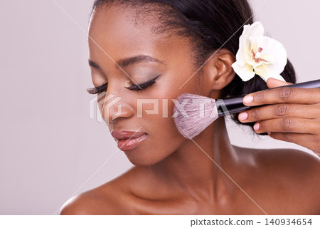 Cosmetic glow, makeup brush on face and black woman with skincare in studio, cosmetics tool. Skin care, blush and foundation, African beauty model with luxury contour highlight on pink background Cosmetic glow, makeup brush on face and black woman with skincare in studio, cosmetics tool. Skin care, blush and foundation, African beauty model with luxury contour highlight on pink background 140934654