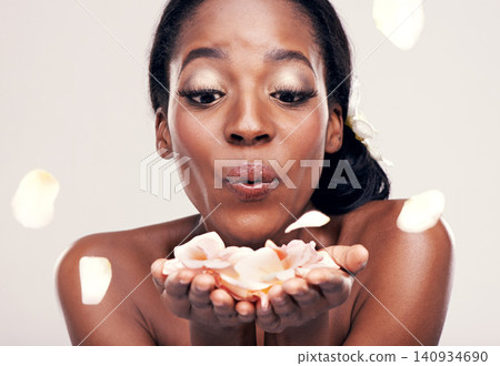 Petal, blow and black woman in studio for makeup, beauty or wellness on white background. Floral, face and African model smile with soft cosmetics, shine or organic, fun and skincare transformation 140934690
