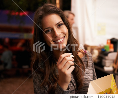 Portrait, smile and popcorn with a woman at a music festival for a concert, show or live performance. Party, food and summer with a happy young person eating a snack outdoor at a carnival event Portrait, smile and popcorn with a woman at a music festival for a concert, show or live performance. Party, food and summer with a happy young person eating a snack outdoor at a carnival event 140934958