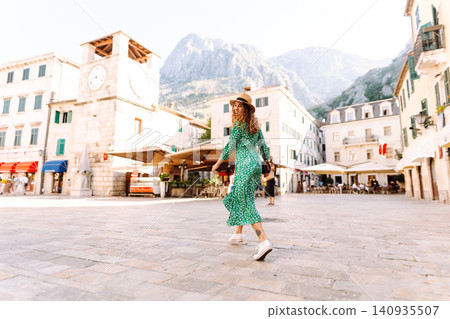 Happy smiling woman wearing trendy summer outfit walking in street of European city. Fashion Happy smiling woman wearing trendy summer outfit walking in street of European city. Fashion 140935507