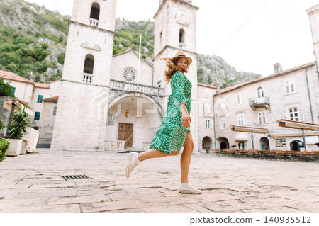 Happy female tourist in beautiful dress walking in the street of the city. Fashion style. Happy female tourist in beautiful dress walking in the street of the city. Fashion style. 140935512