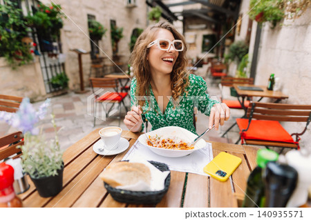 Woman eating italian pasta and drinking coffee at restaurant on the street in Rome. Food and drink. Woman eating italian pasta and drinking coffee at restaurant on the street in Rome. Food and drink. 140935571