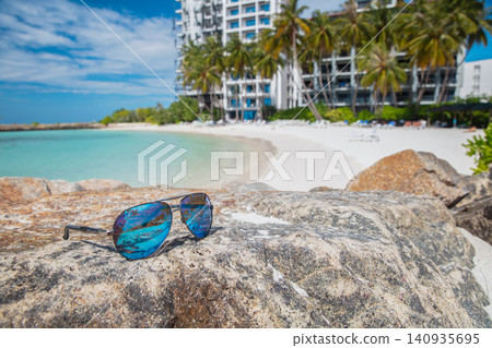 Sunglasses lie on a rock Sunglasses lie on a rock 140935695