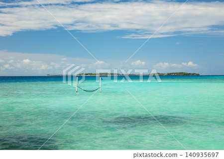 Tropical island coast as summer landscape with swing or hammock Tropical island coast as summer landscape with swing or hammock 140935697