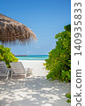 Beautiful tropical scenery, two sun beds, loungers, umbrella under tree. 140935833