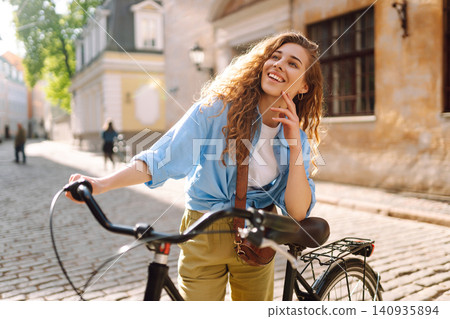 Happy woman tourist using bicycle in city street. Free time after work and study, lifestyle. 140935894