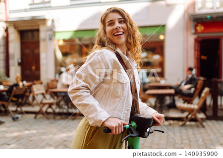 Happy woman rides electric scooter at weekend leisure time. Ecological transport. Active lifestyle. Happy woman rides electric scooter at weekend leisure time. Ecological transport. Active lifestyle. 140935900