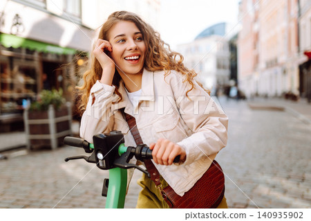 Happy woman rides electric scooter at weekend leisure time. Ecological transport. Active lifestyle. Happy woman rides electric scooter at weekend leisure time. Ecological transport. Active lifestyle. 140935902
